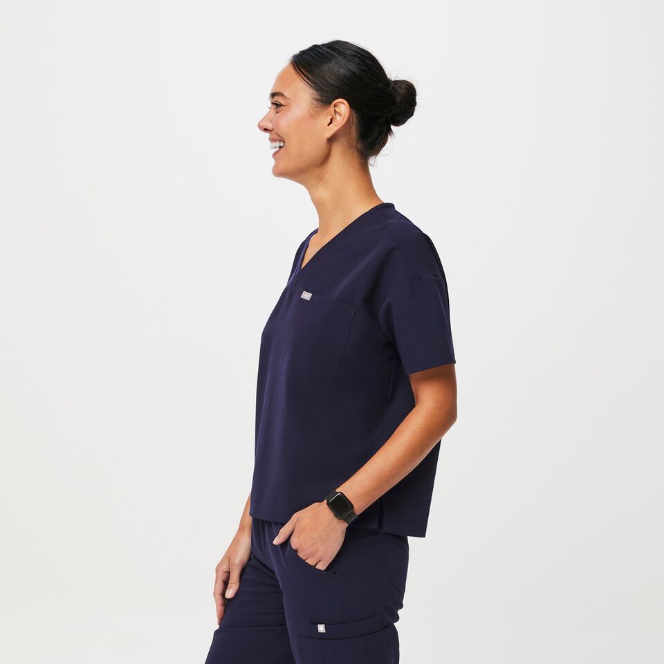 https://creative.wearfigs.com/asset/774ccc6c-0c05-4082-b42c-9ae64bc5228a/SQUARE/Q3_2023_07_NAVY_OVERSIZED-CATARINA_W_LOGAN_06819