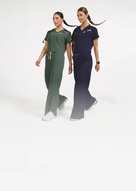 Healthcare professionals wearing FIGS cropped scrub tops and wide-leg scrub pants in Charcoal and Moss, introducing the brand's new trend-driven silhouettes.