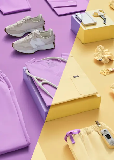 Flat lay featuring FIGS scrubs, accessories, and medical essentials in Wild Iris and Butter Yellow from the Never Change collection.