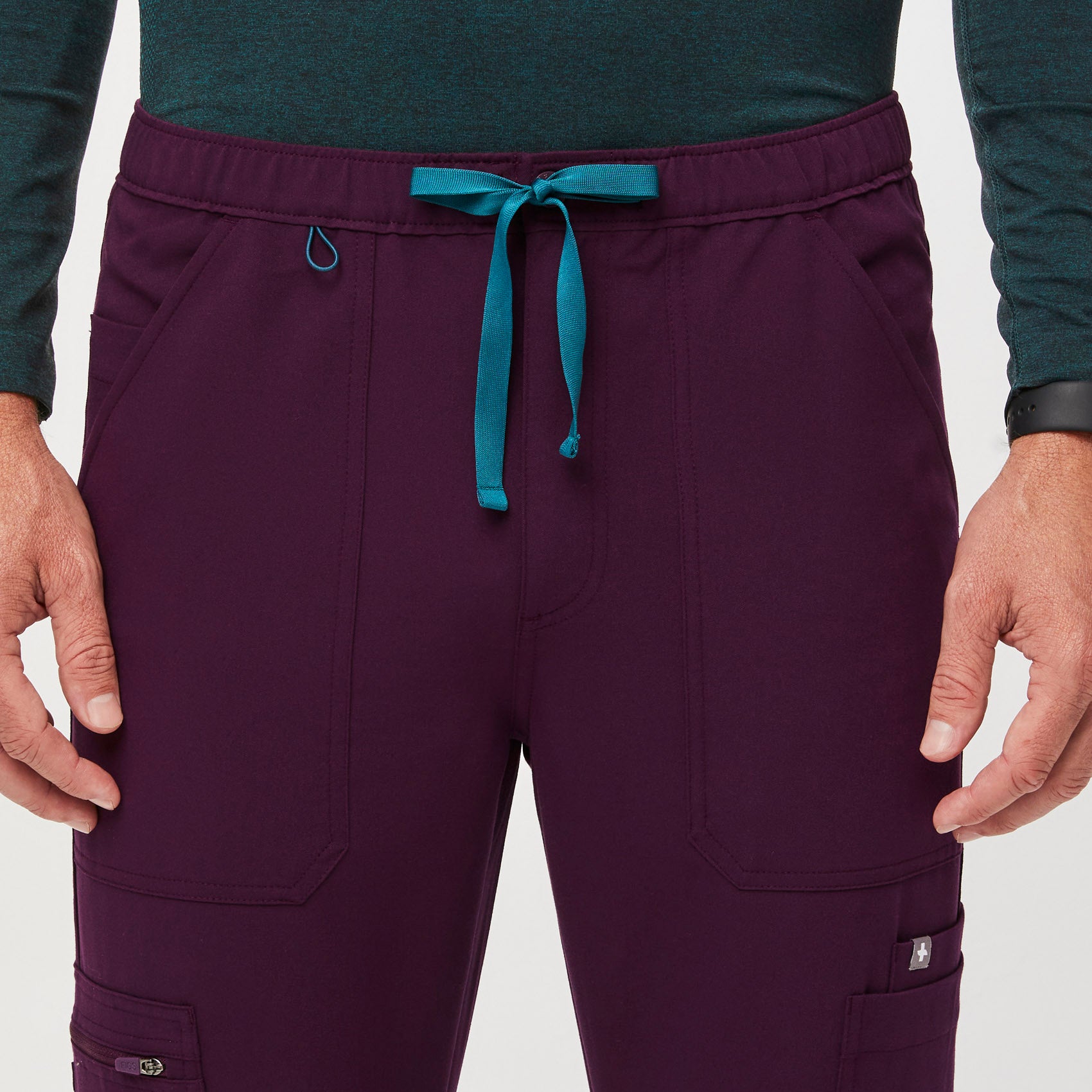 https://cdn.shopify.com/s/files/1/0139/8942/files/Q2_2023_06_DEEP-PURPLE_CAIRO-CARGO-SCRUB-PANTS_M_COREY_34630.jpg?v=1690222200