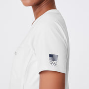 https://cdn.shopify.com/s/files/1/0139/8942/files/Q2_2024_5_WHITE_TEAMUSASCRUBTOP_DEJA_304.jpg?v=1720656356
