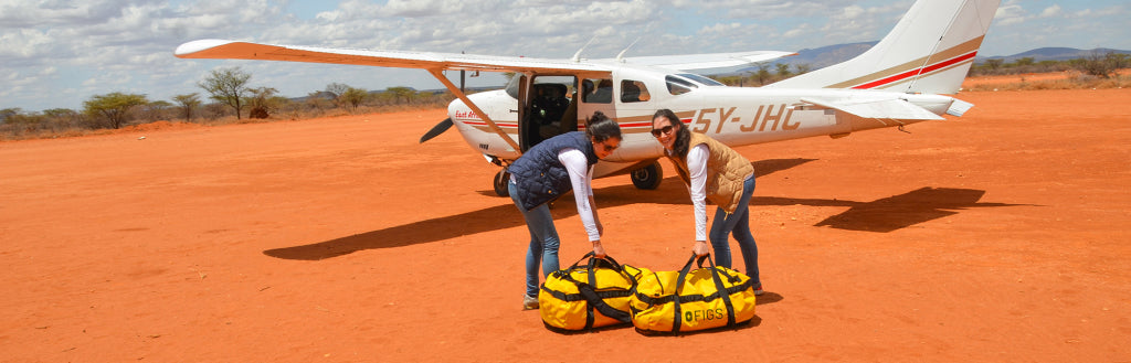 Picture of Heather Hasson and Trina Spear by a plane loading Threads for Threads supplies.