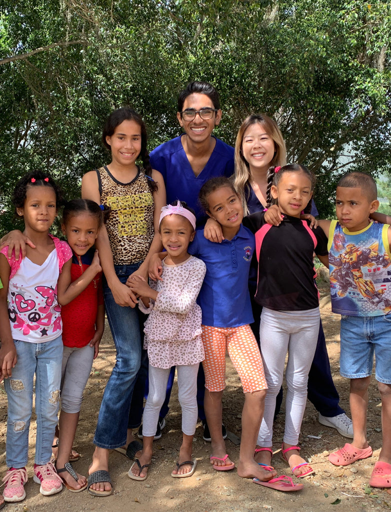 Two nurses surrounded by children